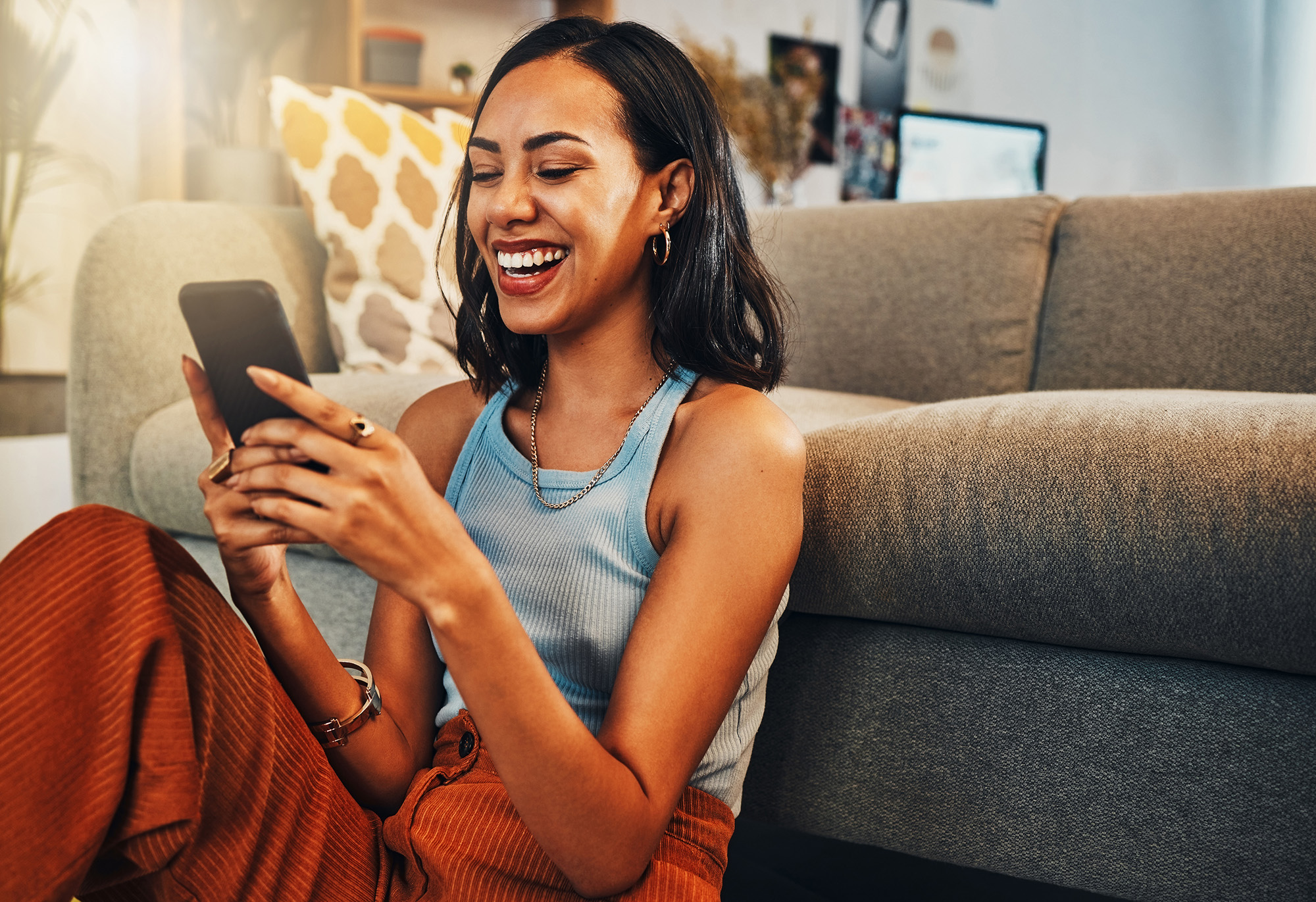 Smiling woman on cellphone in front of couch