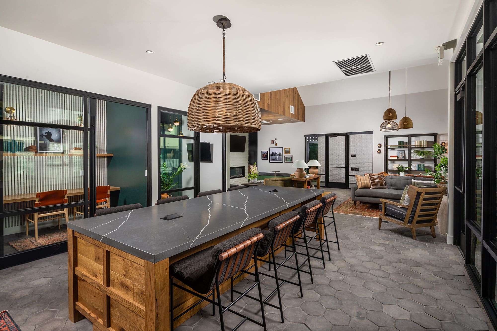 Resident lounge at our apartments for rent in San Diego, featuring a long table with chairs and a view of the meeting room.