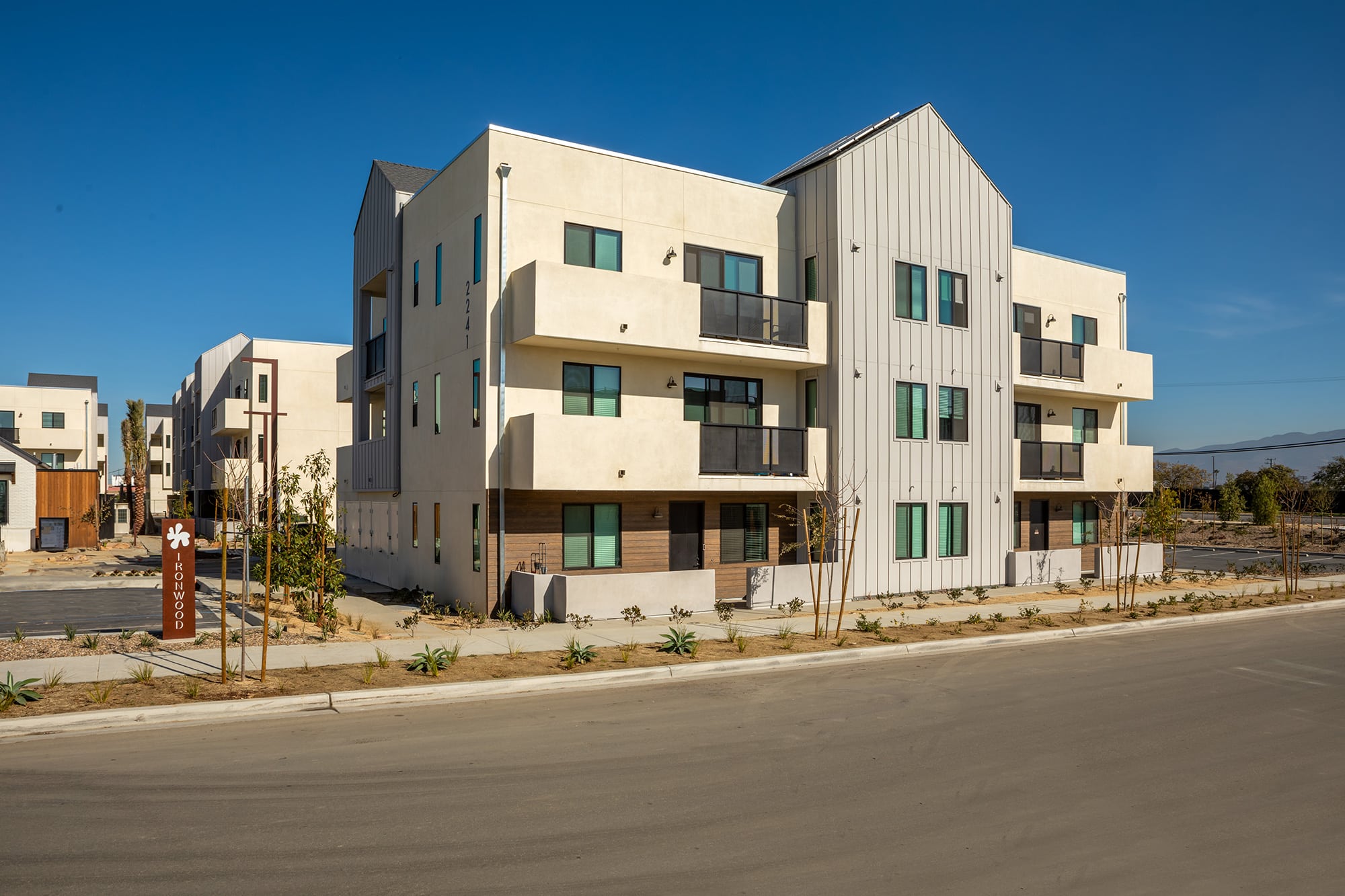 The exterior of the Ironwood Apartments in South San Diego, featuring a modern facade and a view of the parking spots.