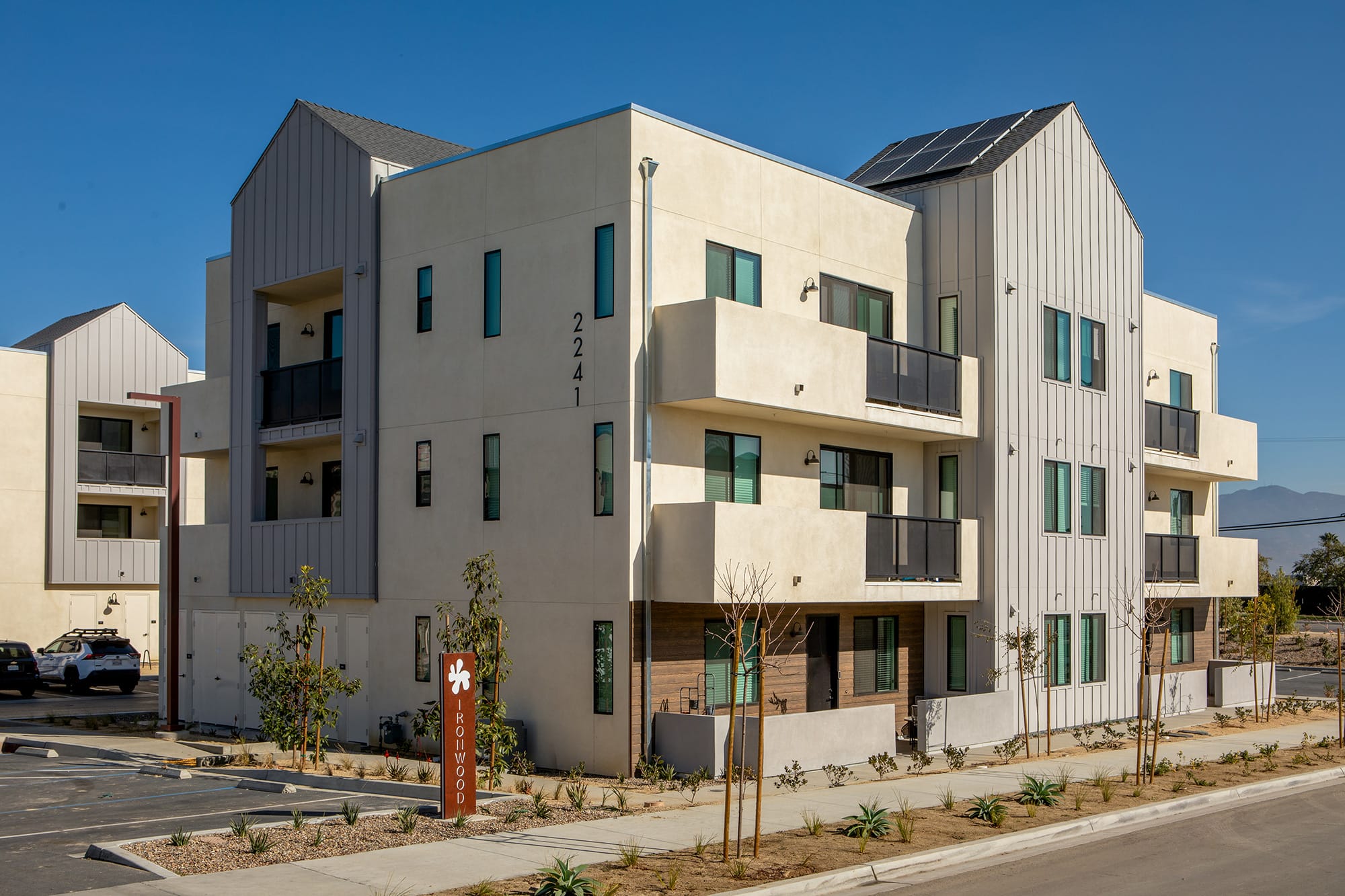 The exterior of the Ironwood Apartments in South San Diego, featuring a modern facade and a view of the parking spots.